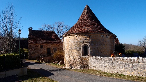 Vue de l’église avec son abside et son cimetière situé derrière le muret